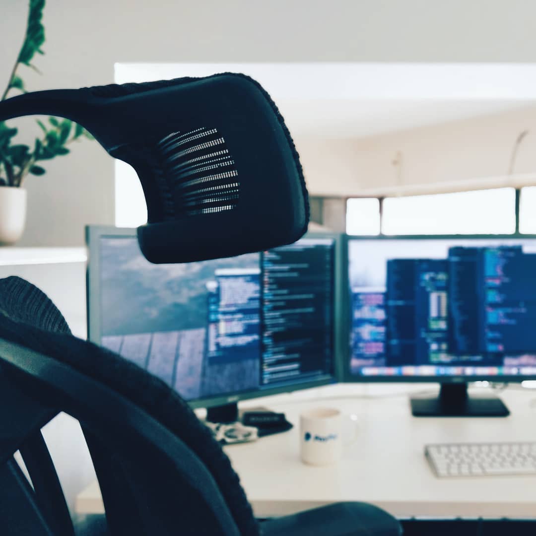 A digital agency desk, computer screens behind it, blurred. Bokeh.